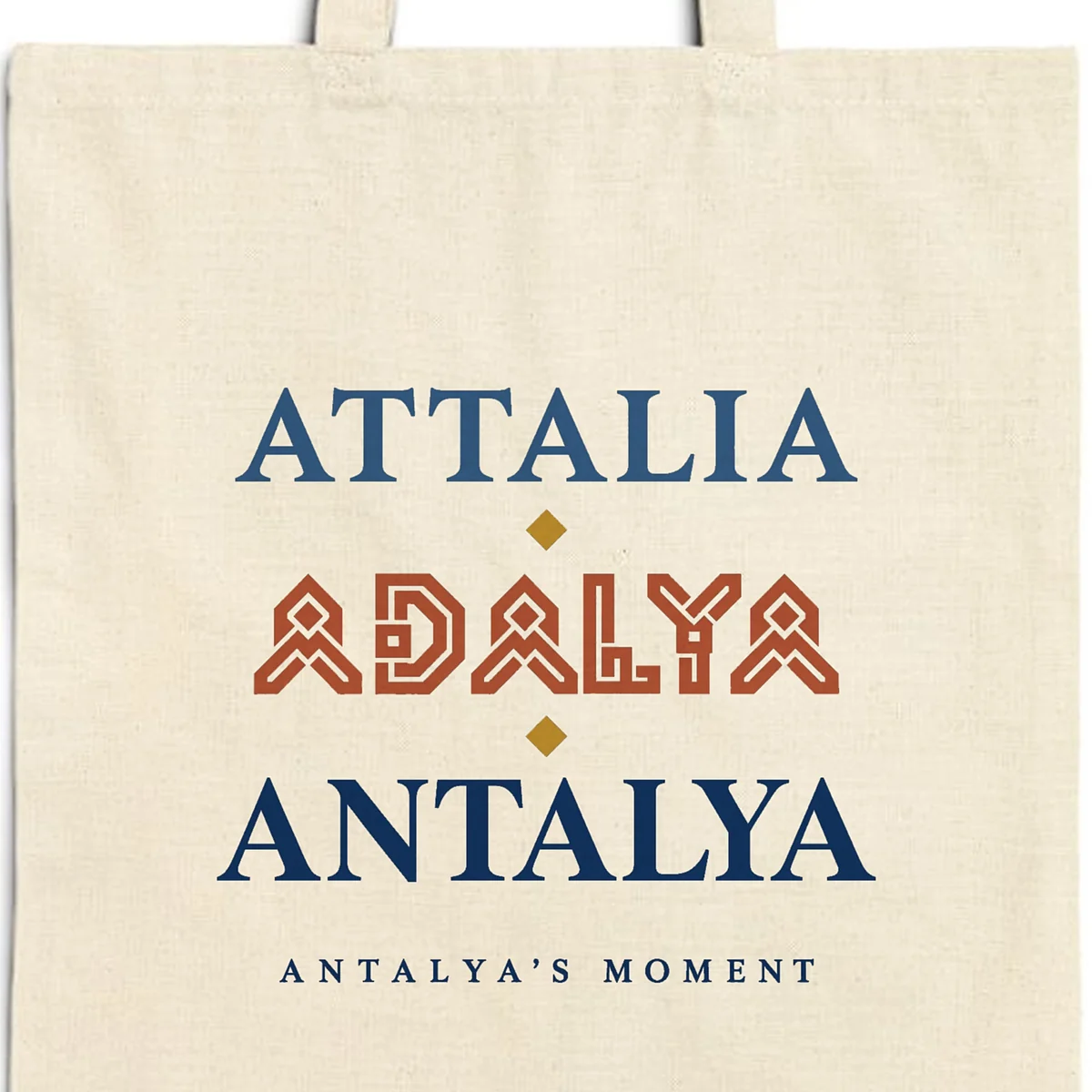 Close-up of the Attalia Adalya Antalya design printed on a natural canvas tote, with the top seam and handles