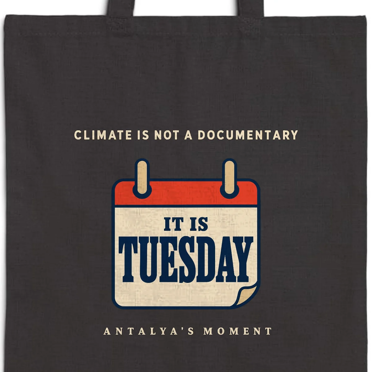 Close-up of the Climate Is Not a Documentary Night design printed on a black canvas tote, with the top seam and handles