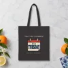 Climate Is Not a Documentary Night design on a black canvas tote, laid flat