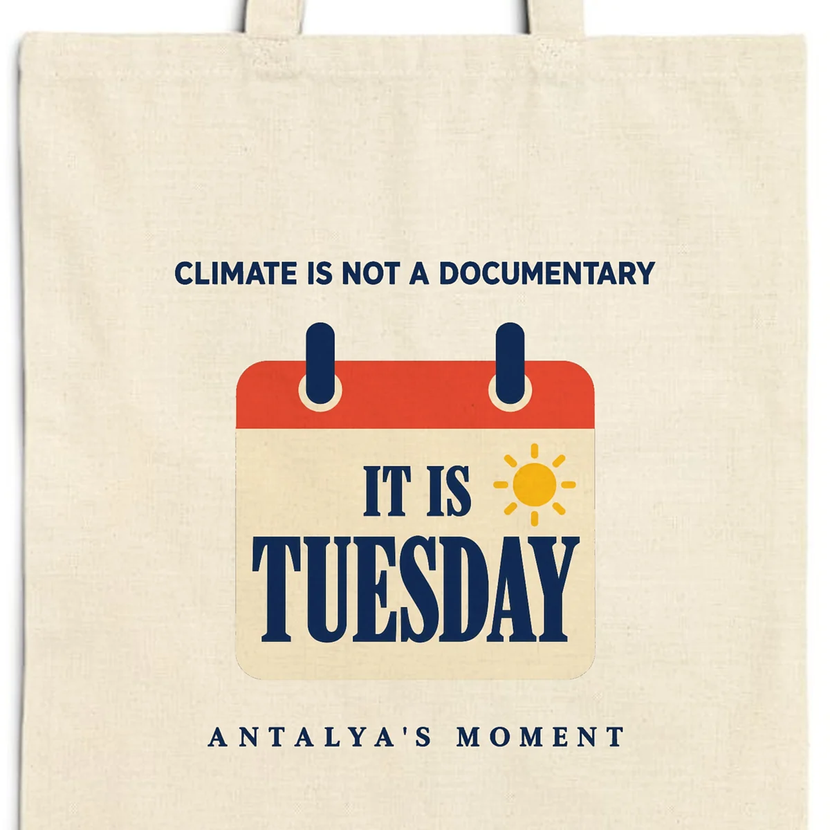 Close-up of the Climate Is Not a Documentary design printed on a natural canvas tote, with the top seam and handles