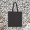 Plain back of the black canvas tote with the Giving Up Is Not Realism Night design, printed on the front only