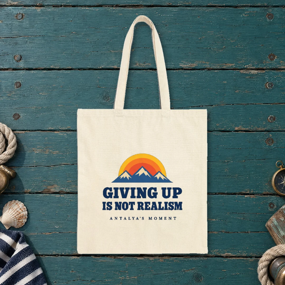 Giving Up Is Not Realism design on a natural canvas tote, laid flat