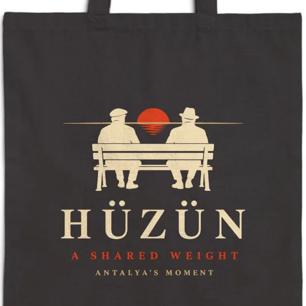 Close-up of the Hüzün Night design printed on a black canvas tote, with the top seam and handles