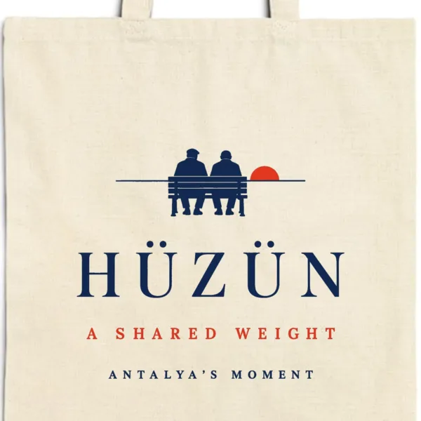 Close-up of the Hüzün design printed on a natural canvas tote, with the top seam and handles