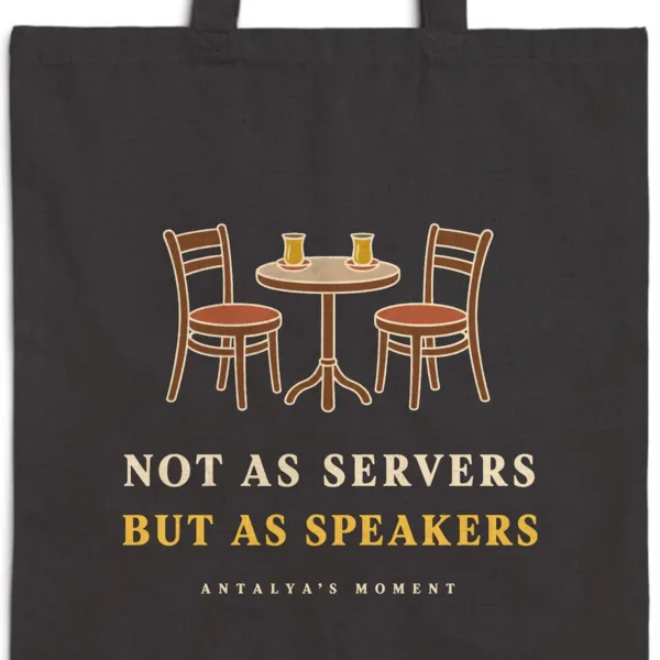 Close-up of the Not as Servers, but as Speakers Night design printed on a black canvas tote, with the top seam and handles