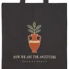 Close-up of the Now We Are the Ancestors Night design printed on a black canvas tote, with the top seam and handles