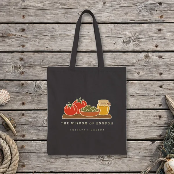 The Wisdom of Enough Night design on a black canvas tote, laid flat