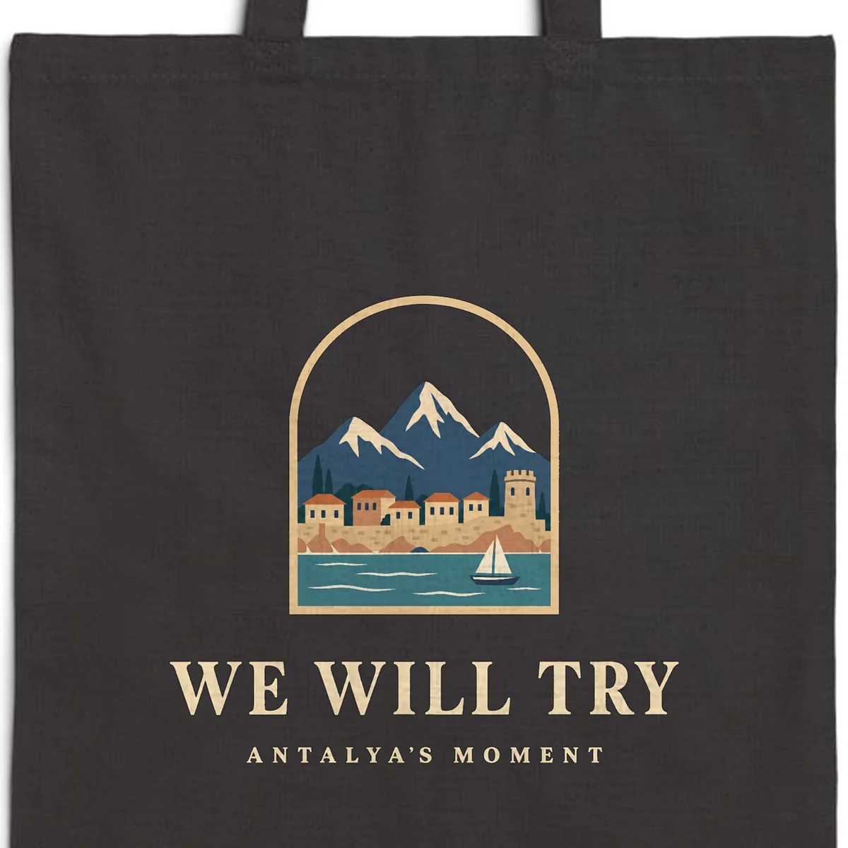 Close-up of the We Will Try Night design printed on a black canvas tote, with the top seam and handles